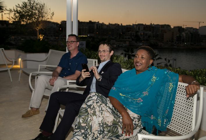 A group of professionals in a relaxed, luxurious outdoor setting.